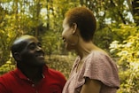 selective focus photography of man and woman near trees