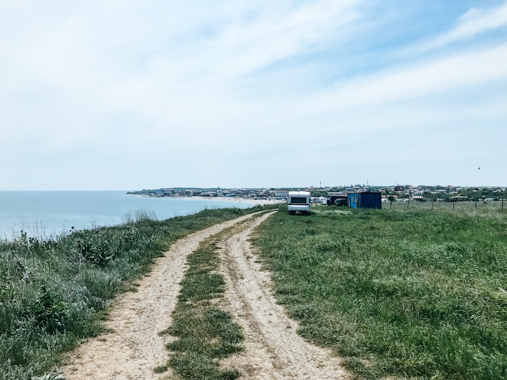 white travel trailer beside body of water