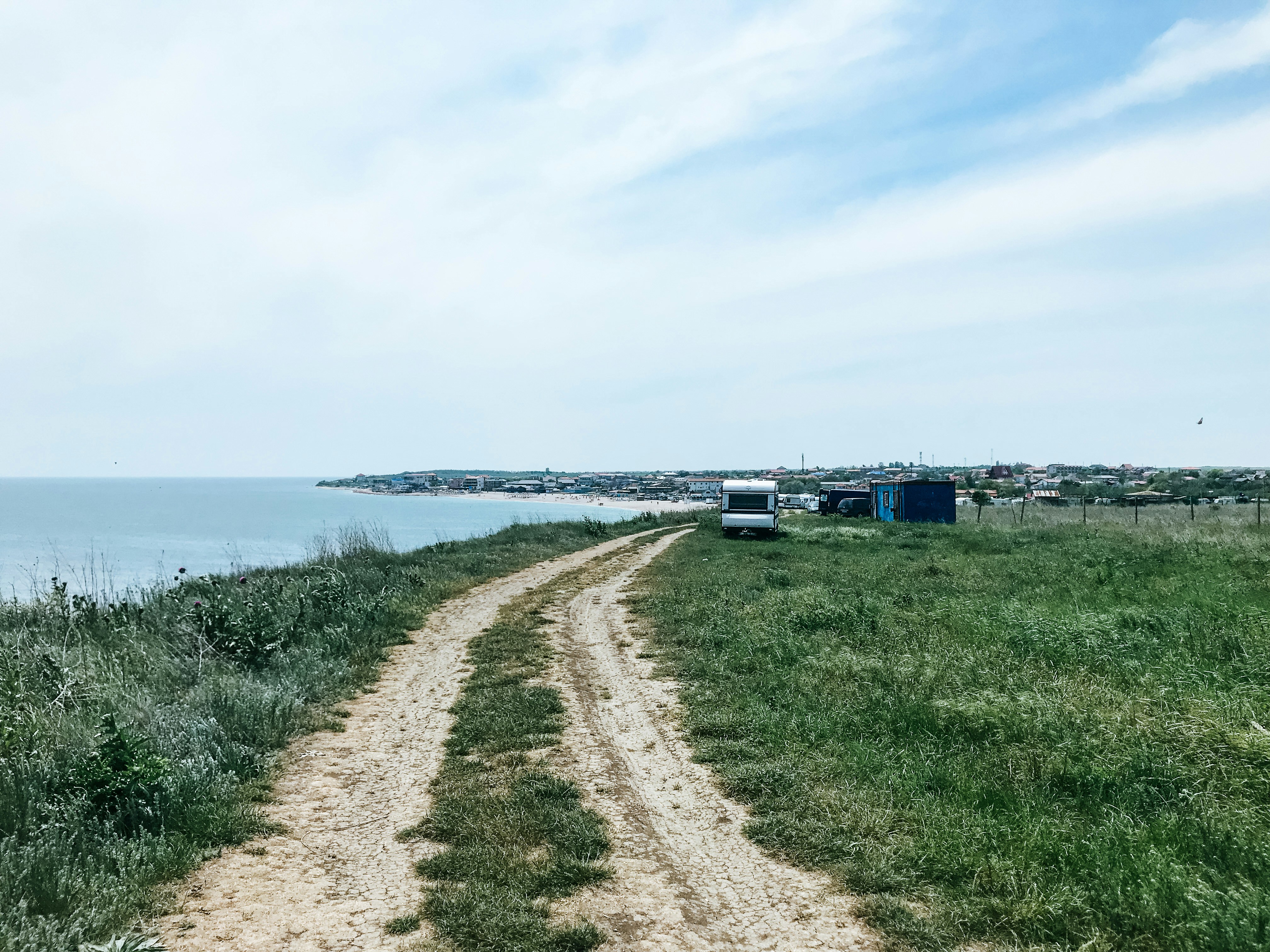 white travel trailer beside body of water