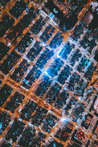 A glowing neon blue and aqua digital map grid overlaying a dark cityscape at night, highlighting data points and connections.