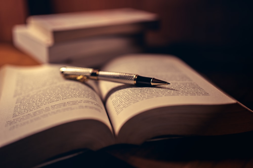 gray click pen on open book photo - Free Brown Image on Unsplash