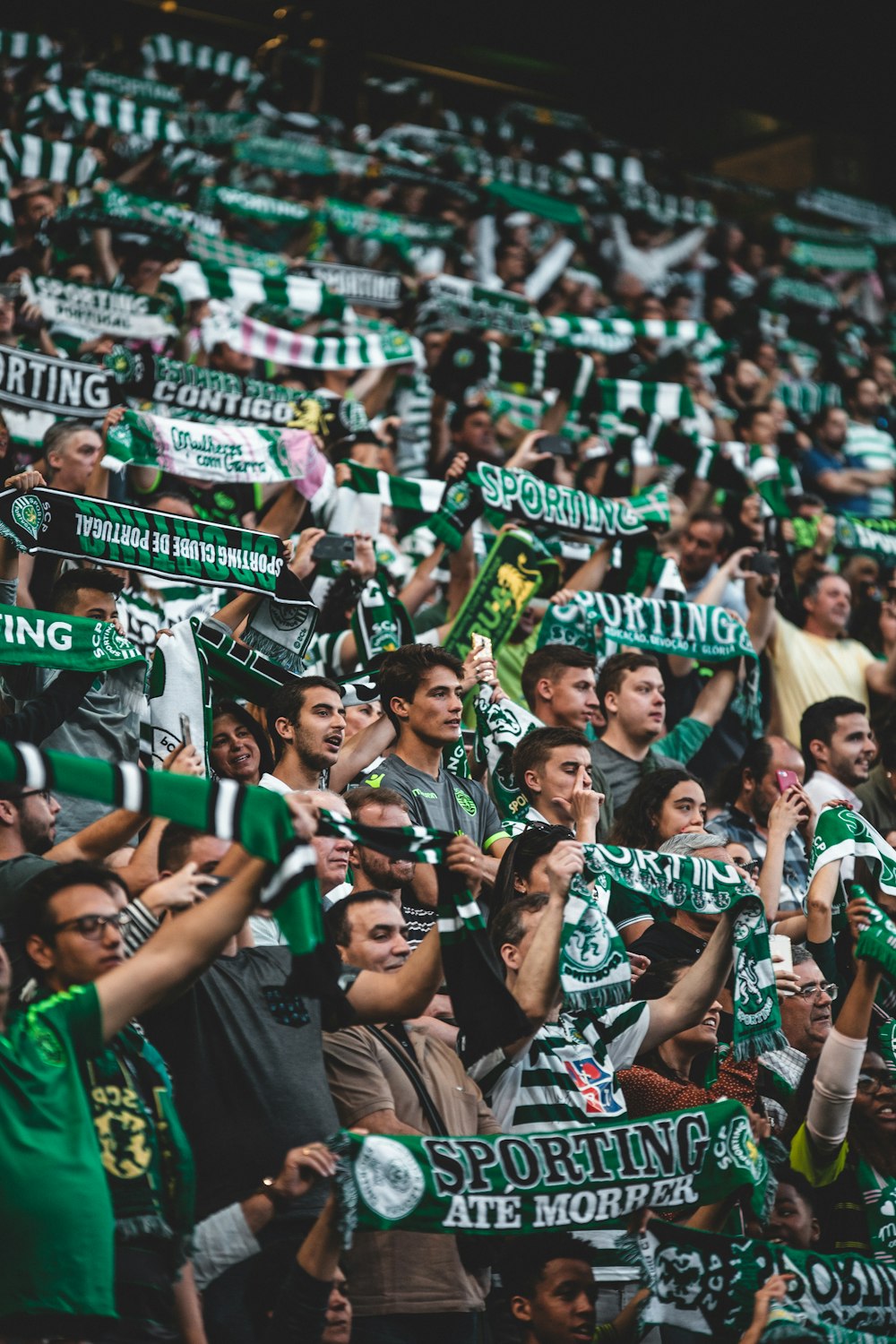 crowd of people standing while holding green banners