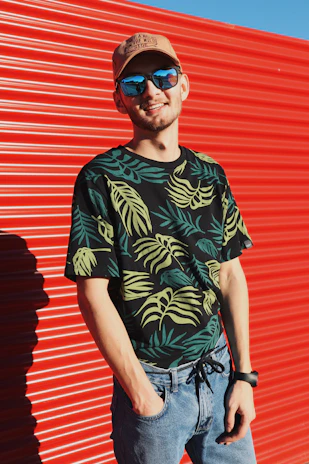 A smiling customer wearing a custom printed t-shirt outdoors, sunlight highlighting the vibrant design.