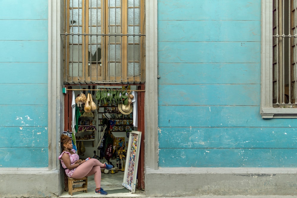 woman sitting beside brown door