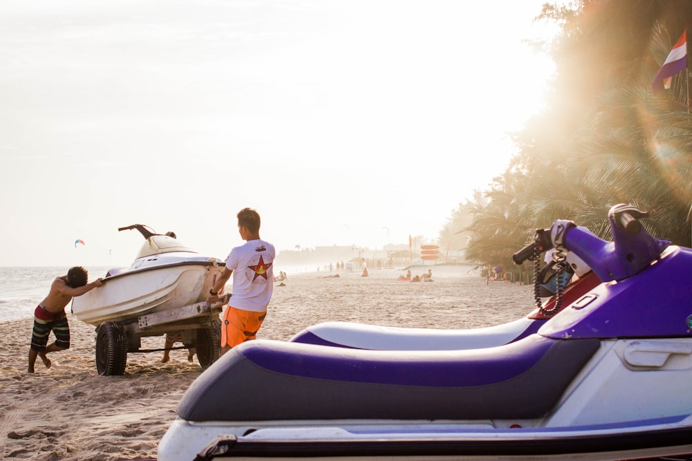 two men pushing white personal watercraft