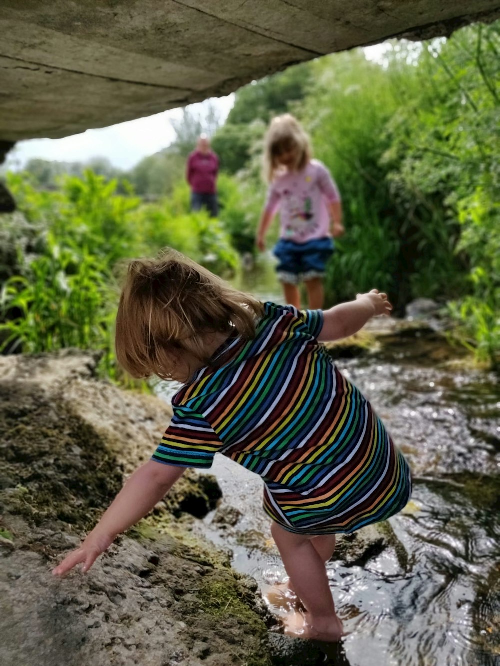 two children walking on water stream