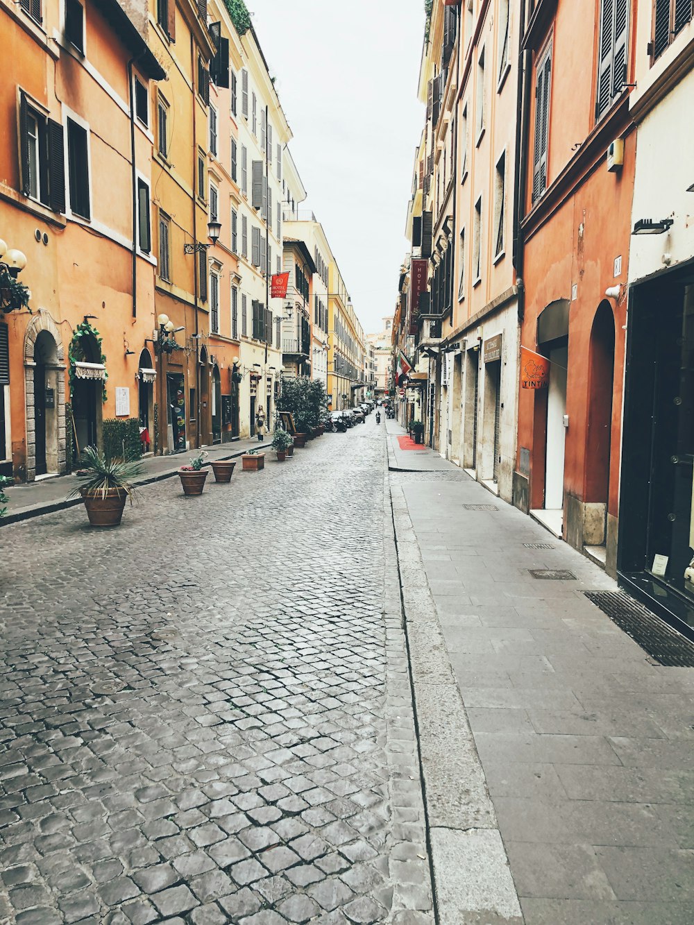 gray pathway beside brown buildings