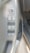 The image features the door panel of a car interior, showing multiple control buttons. The controls include a circular side mirror adjustment knob labeled with 'L' and 'R' for left and right, buttons for window lock and window adjustment, and an 'auto down' button specifically for automatic window lowering. The panel is mainly gray with a textured area near the top.