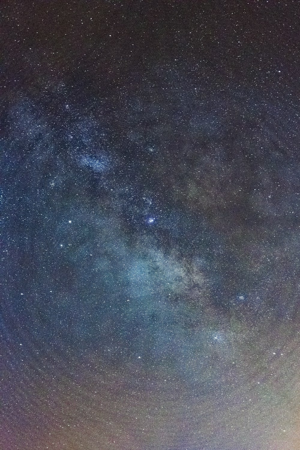 um grupo de pessoas em pé no topo de um campo sob um céu noturno