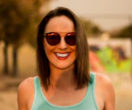 woman in green tank top wearing sunglasses and smiling
