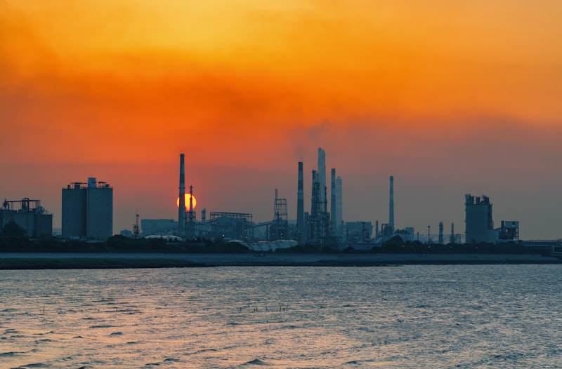 Industrial refinery and chemical plant silhouetted against an orange sunset