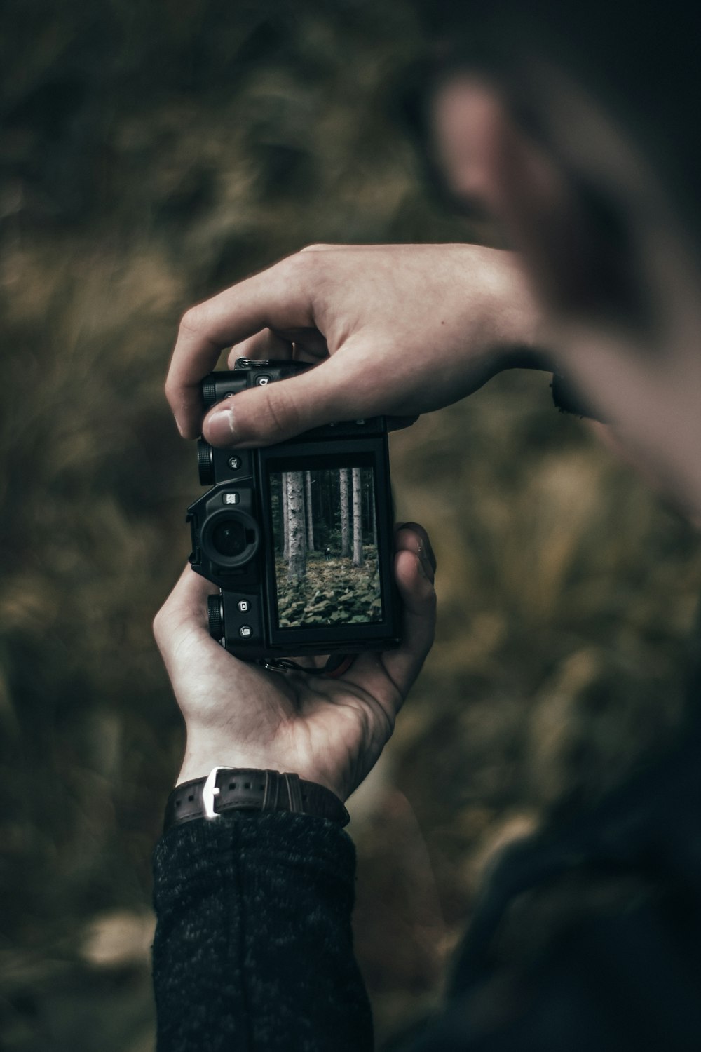 selective focus photography of person holding black camera