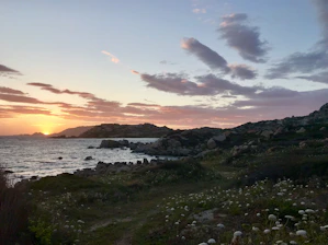 A serene landscape of the lush green hills and coastline of Santa Catarina at sunset.