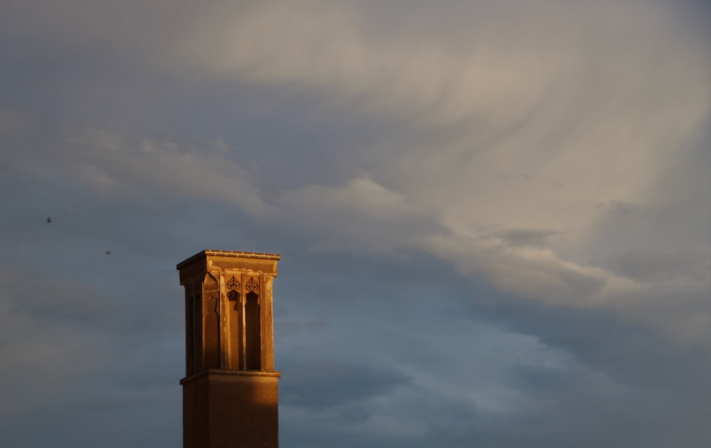 una torre alta con un reloj bajo un cielo nublado