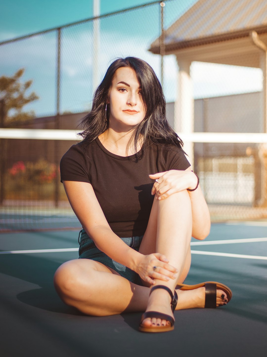 woman sits on tennis court