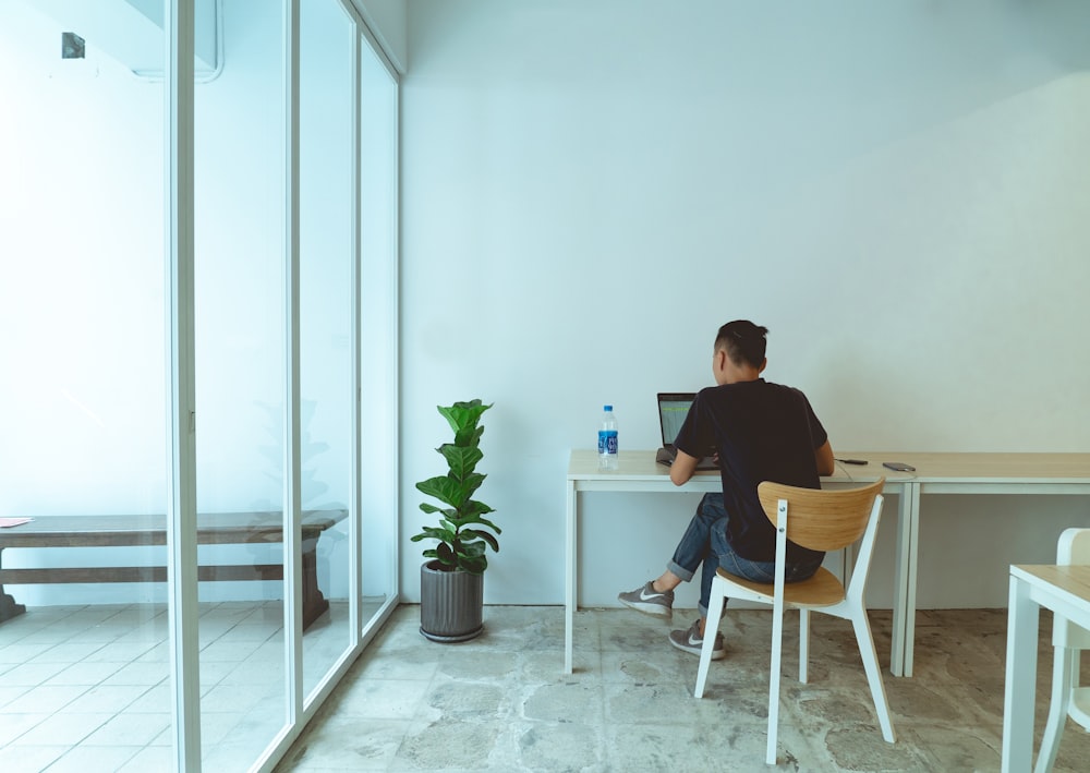 man wearing jeans sitting on chair