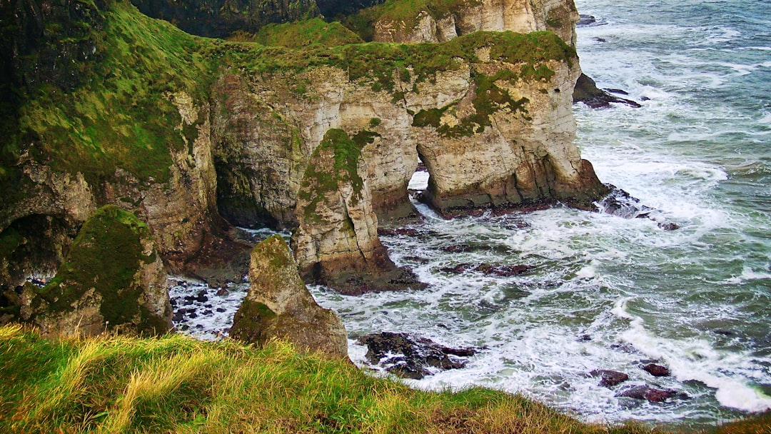 aerial photography of sea waves splashing on mountain walls