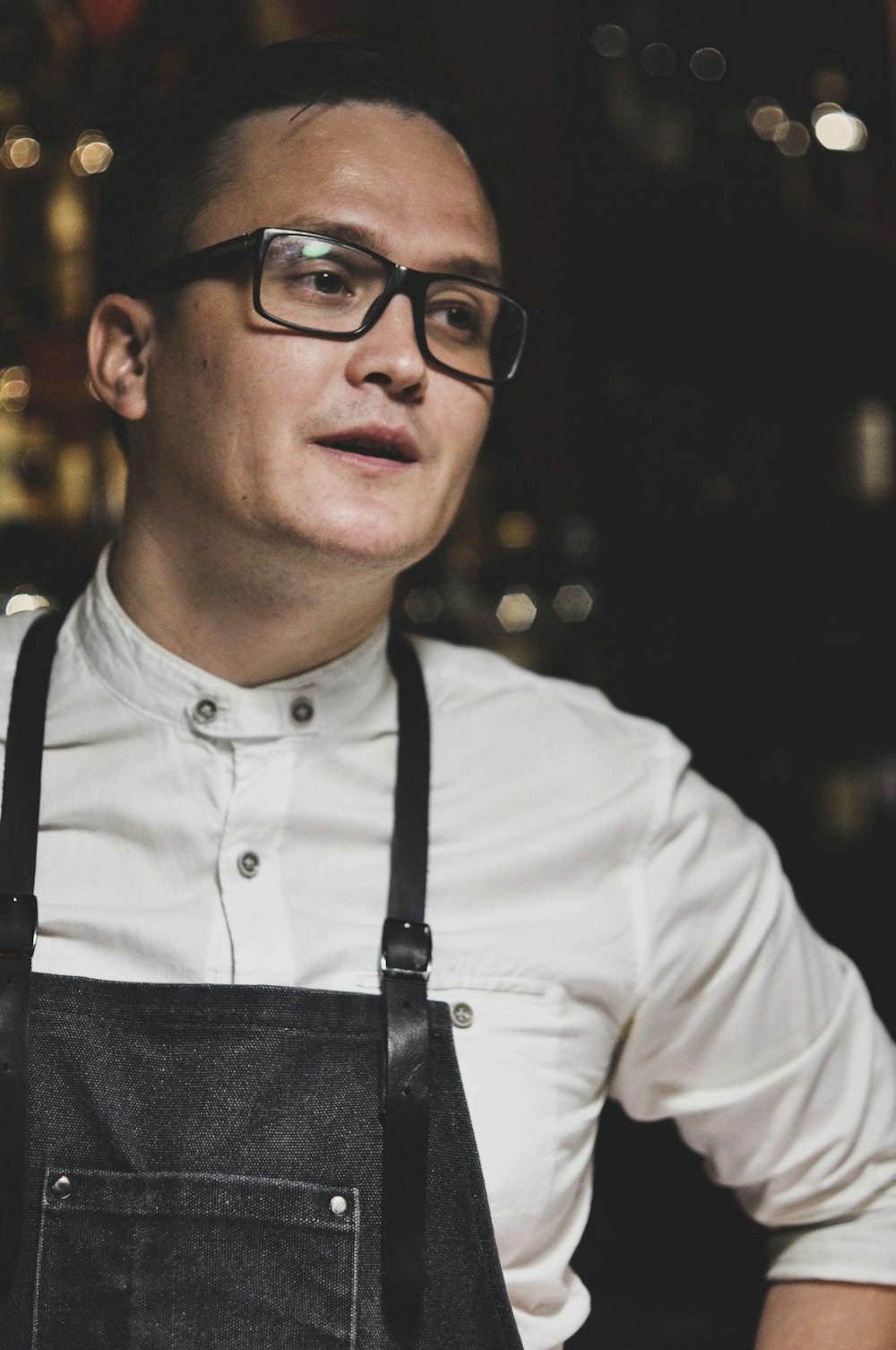 man in white dress shirt and black denim dungarees