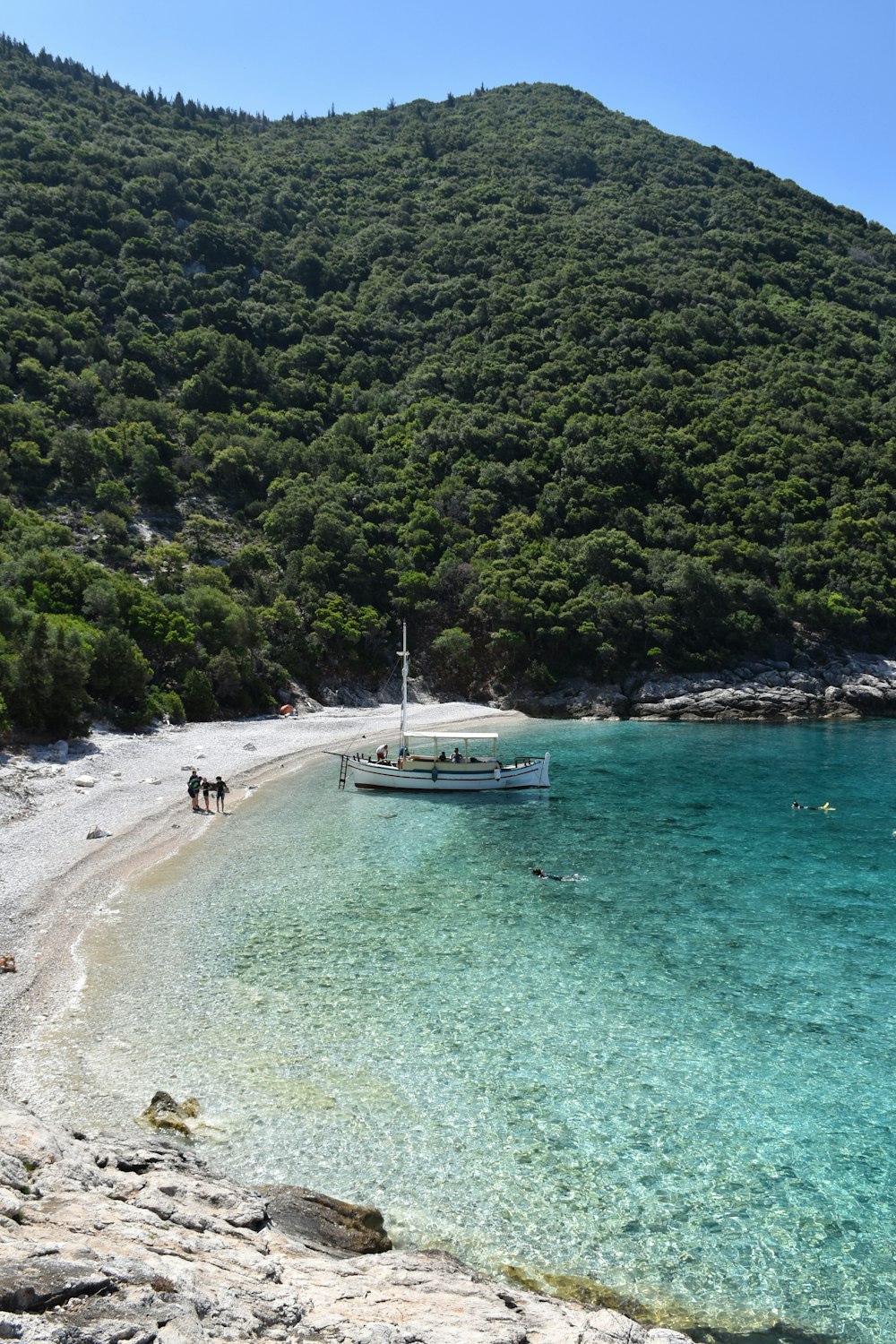 barca bianca vicino alla collina