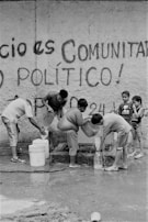 Community members gathered around a newly installed clean water well, smiling and celebrating.