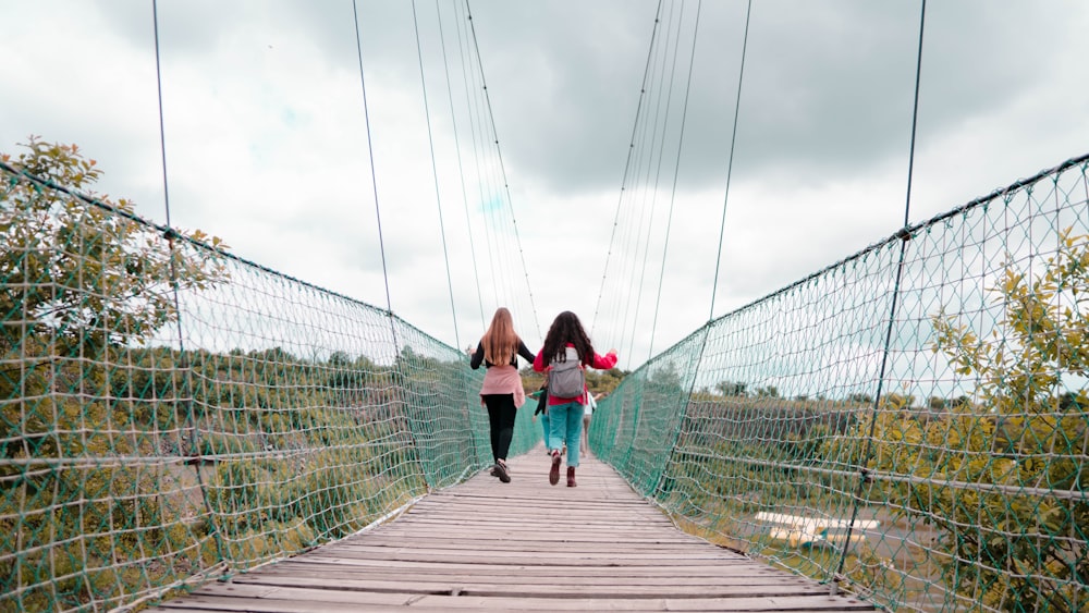 two women walking on hanging bridge