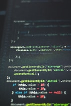 Lines of computer code displayed on a dark screen with syntax highlighting in various colors including green, blue, white, and red.