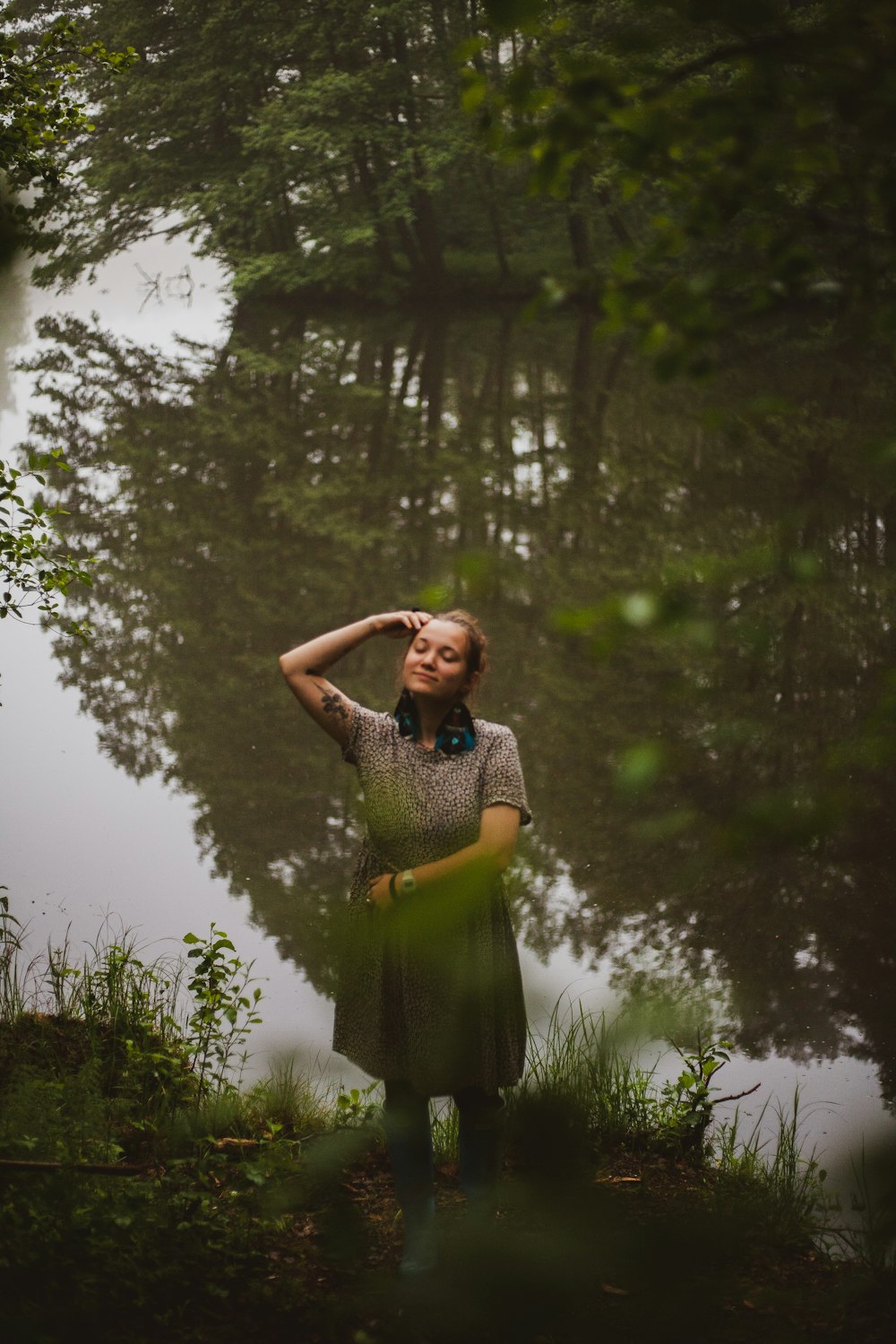 woman standing beside bank of river