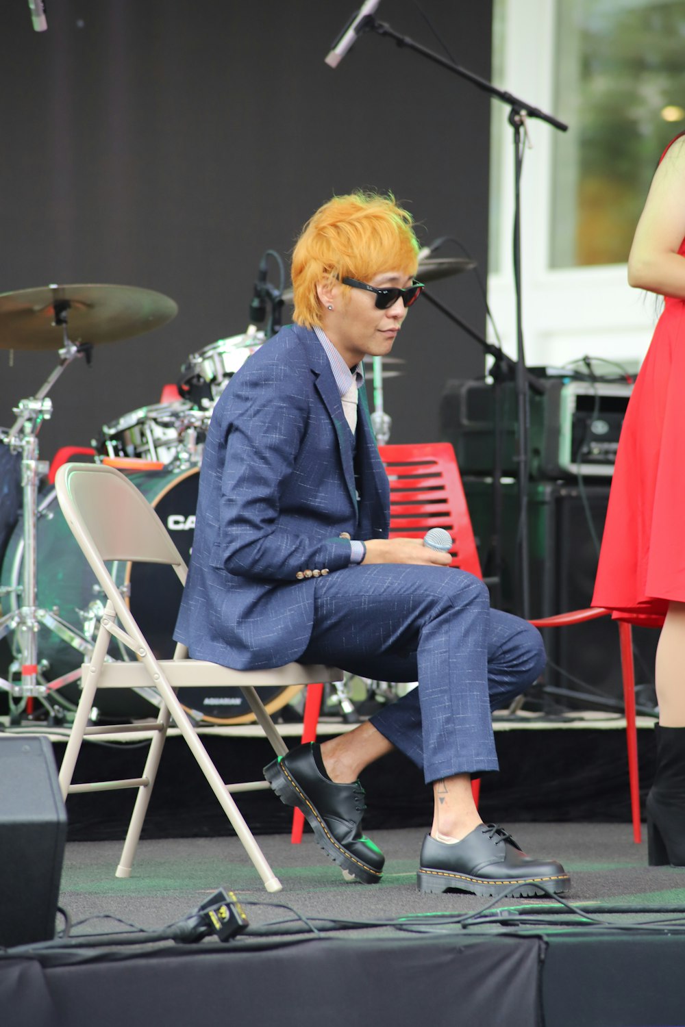 man sitting on stage beside woman