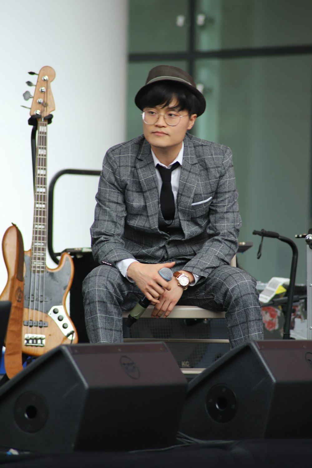 man sitting on folding chair while holding microphone