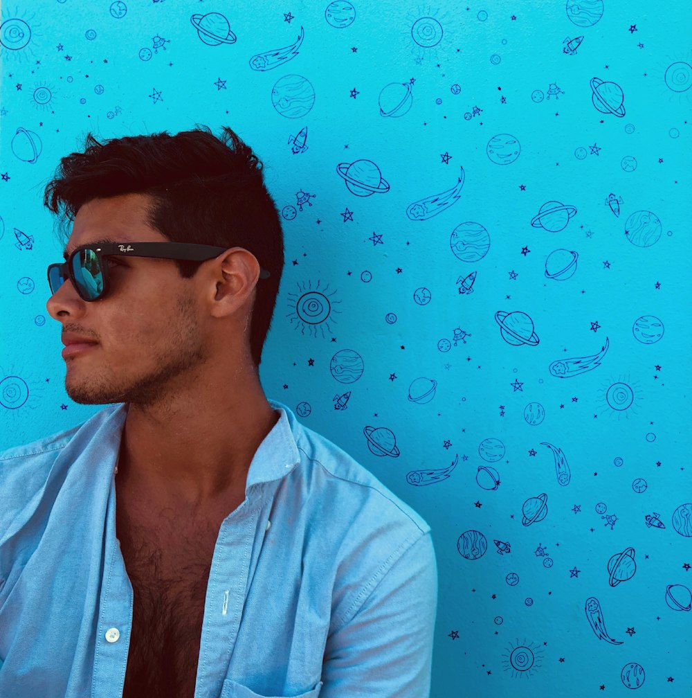 man wearing black framed sunglasses and blue button-up collared top