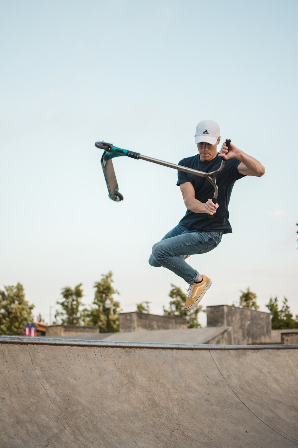 man wearing black crew-neck shirt doing trick on kick scooter