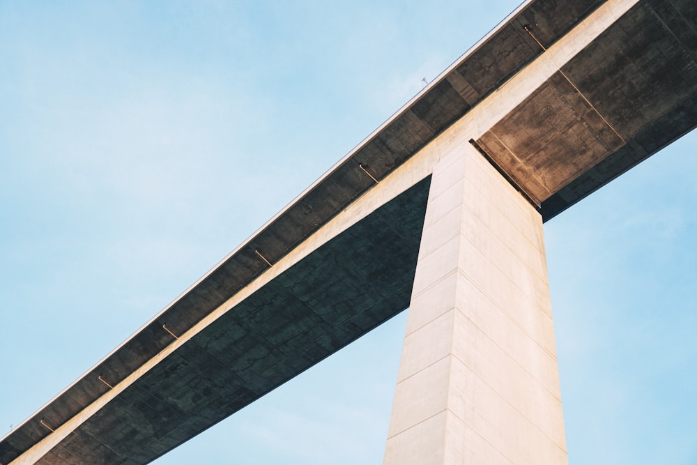 the underside of a bridge against a blue sky