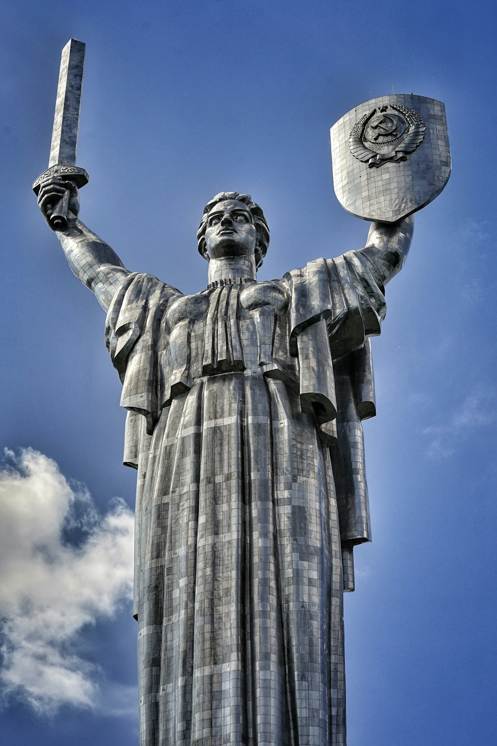 hombre sosteniendo la espada y la estatua del escudo