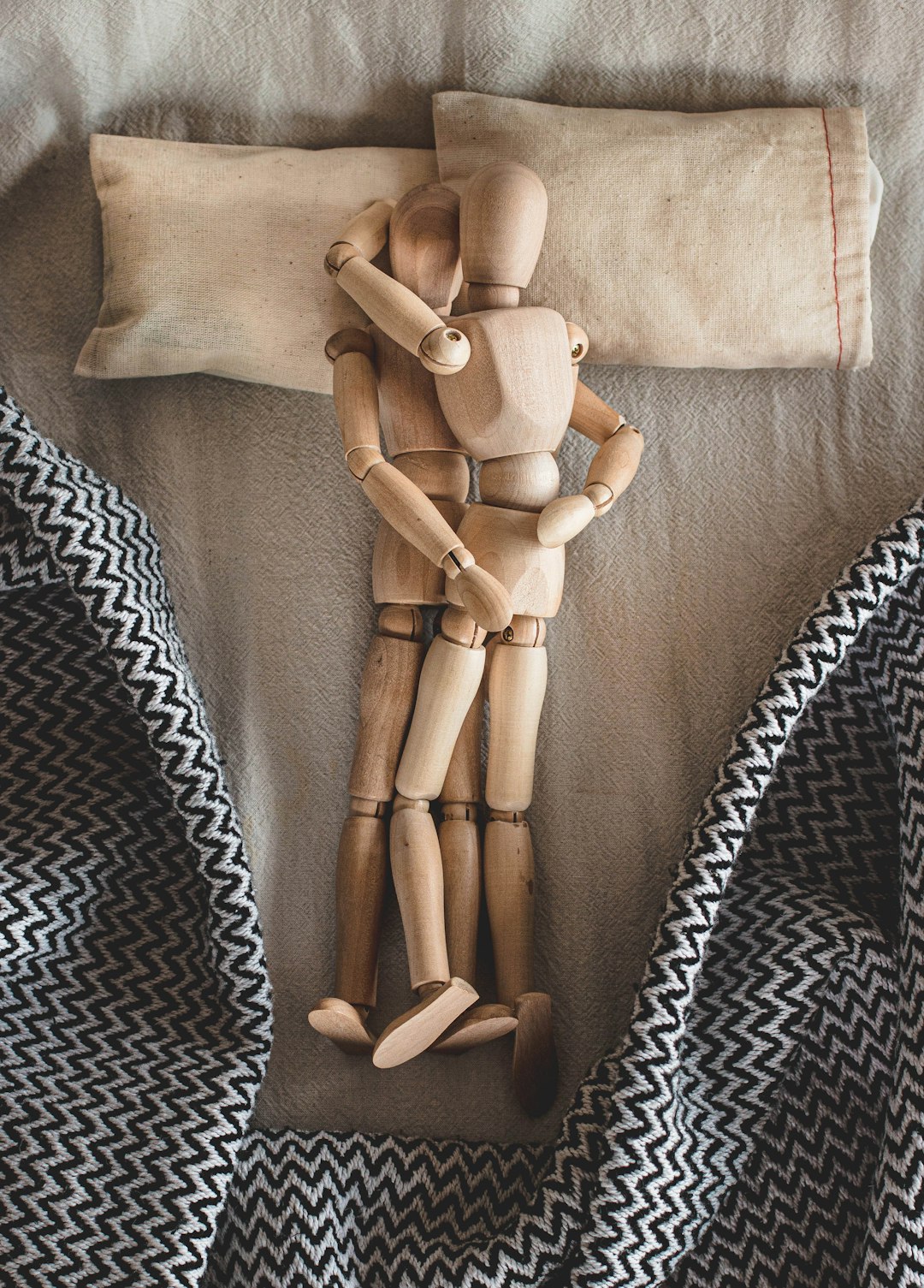 two mannequin hugging laying on bed