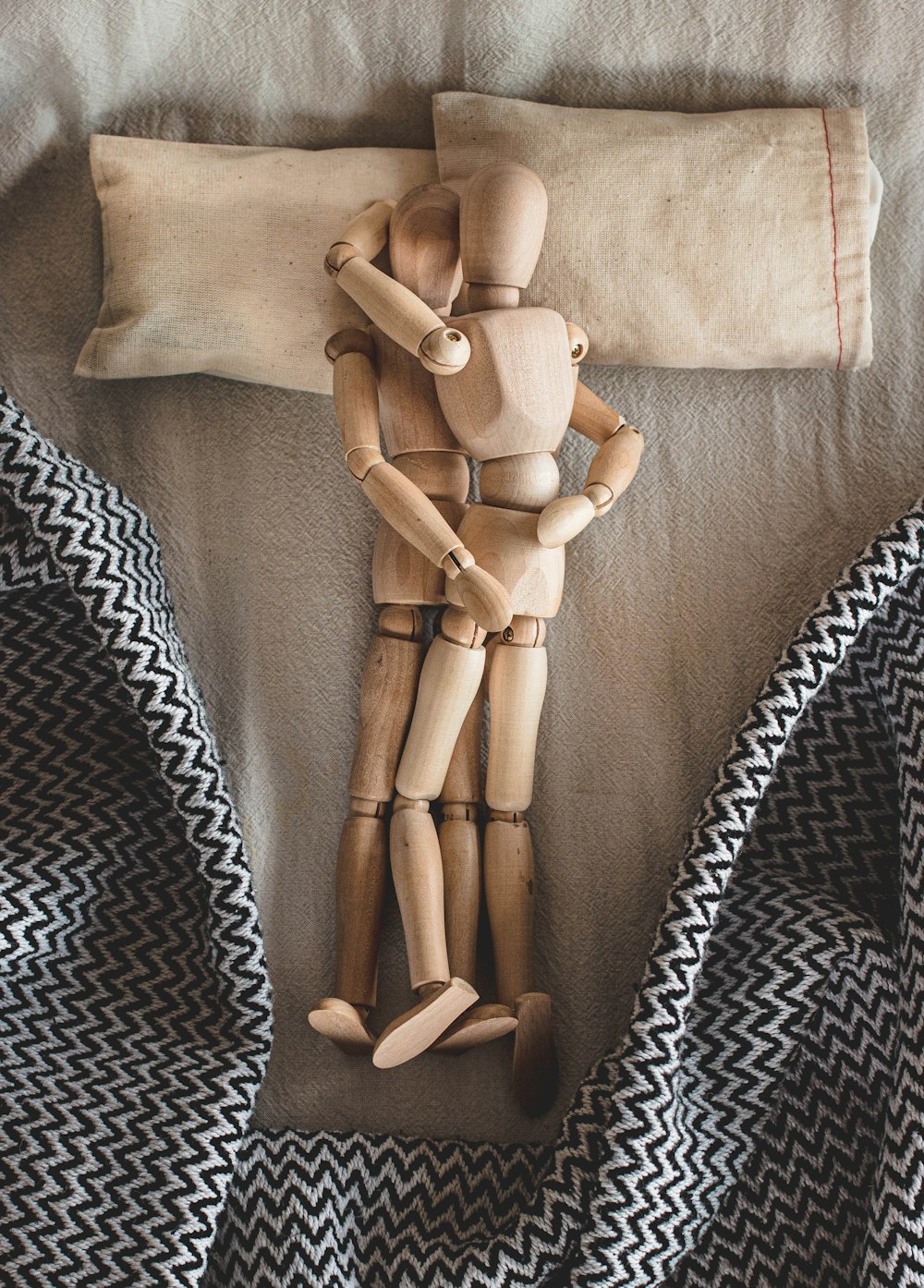 two mannequin hugging laying on bed