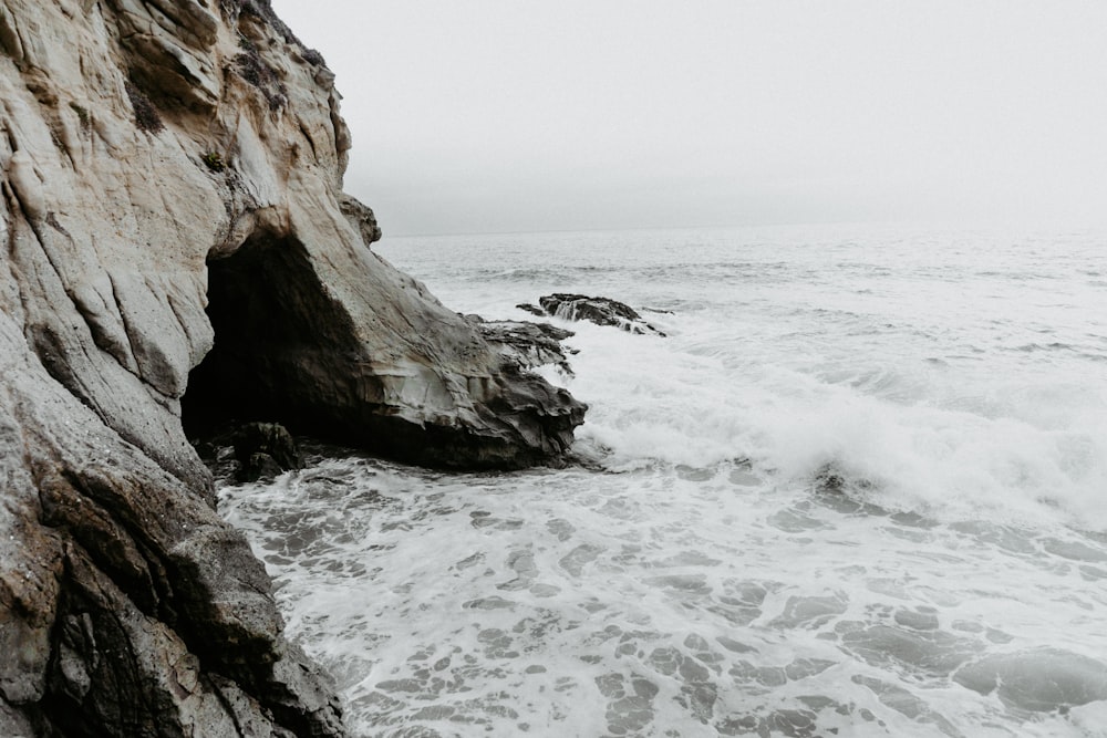 gray mountain cliff beside body of water