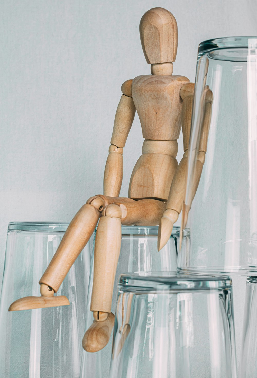 manikin sitting on clear glass cup