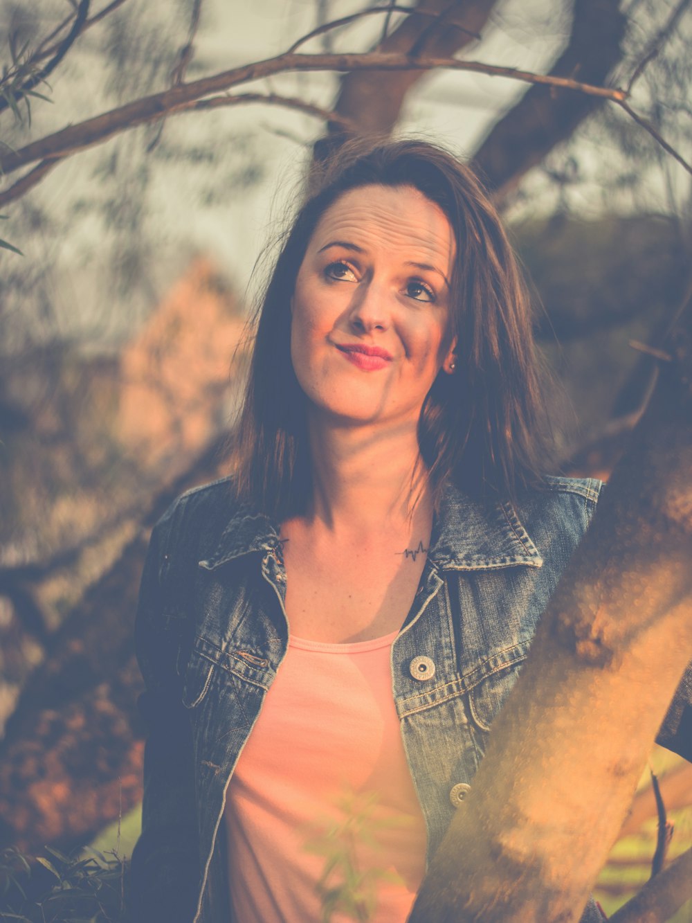 woman wearing blue button-up jacket besides tree