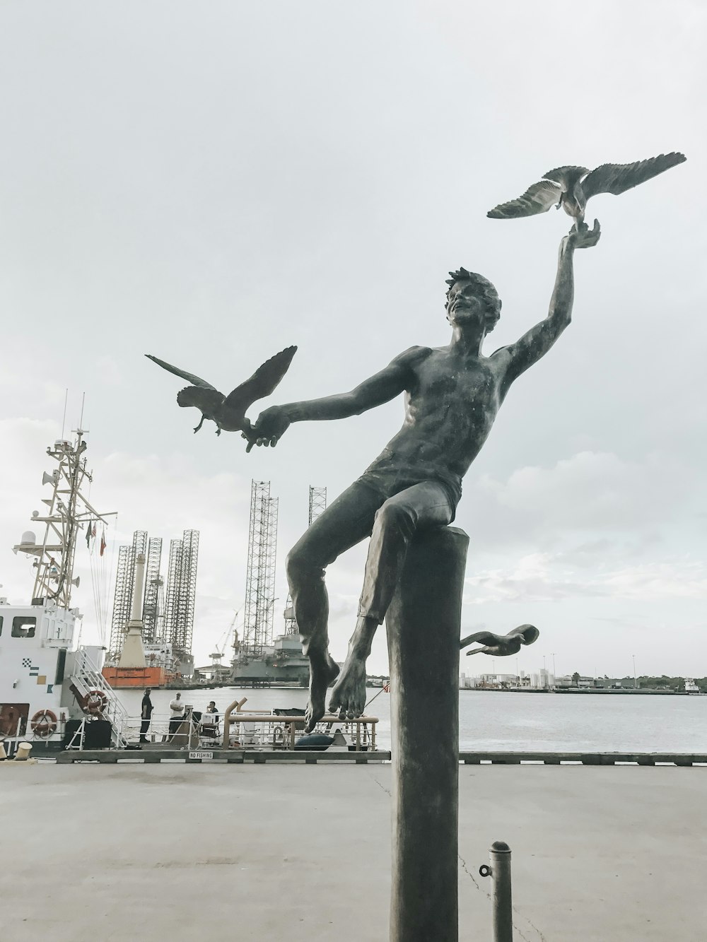 two birds on man's hands statue