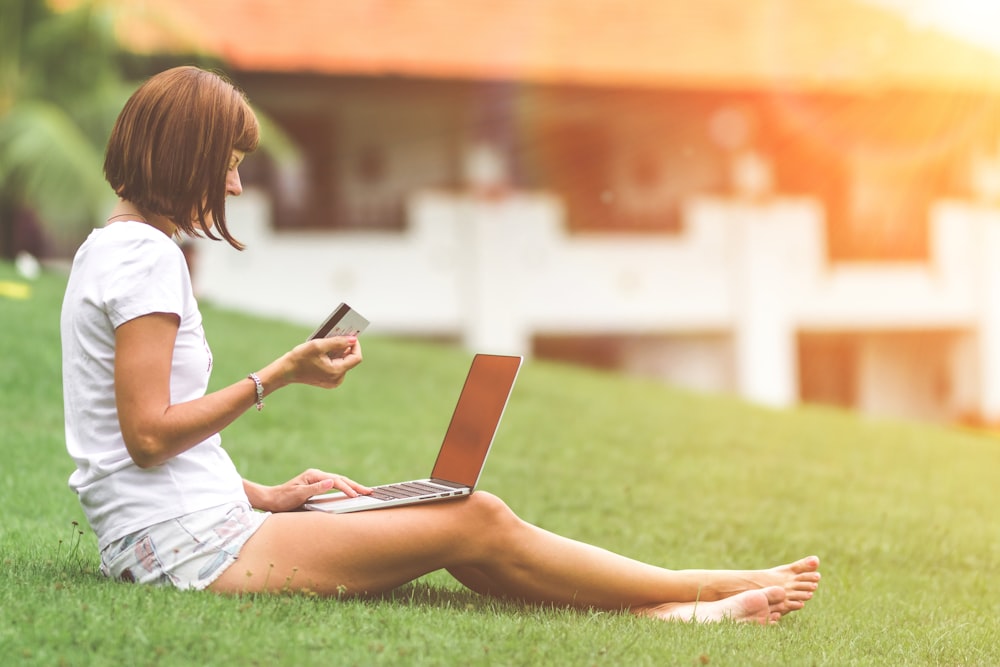 woman sitting on green grass field during daytime