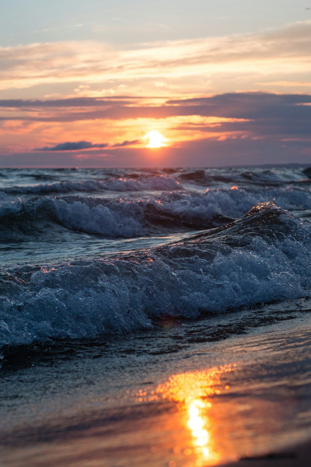Landschaftsfoto einer Meereswelle an einem Strand bei Sonnenuntergang