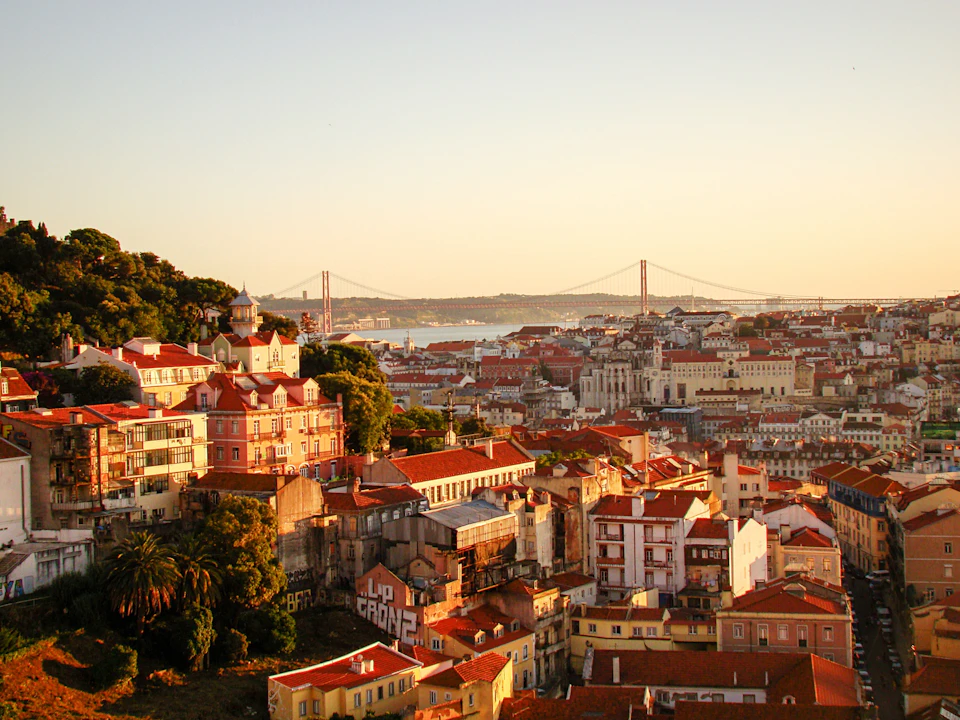 Lisbon rooftops glowing under low golden-hour autumn light