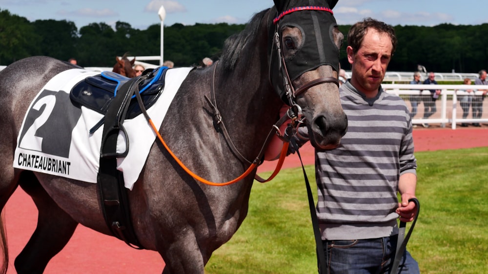 man holding leashed horse