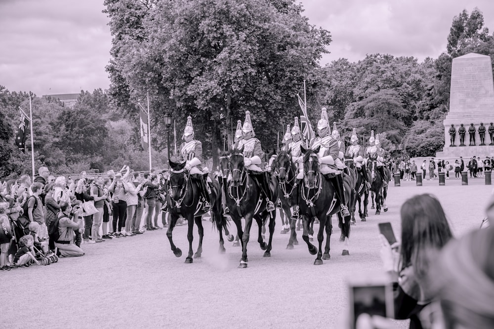 grayscale photography of knights riding on horses