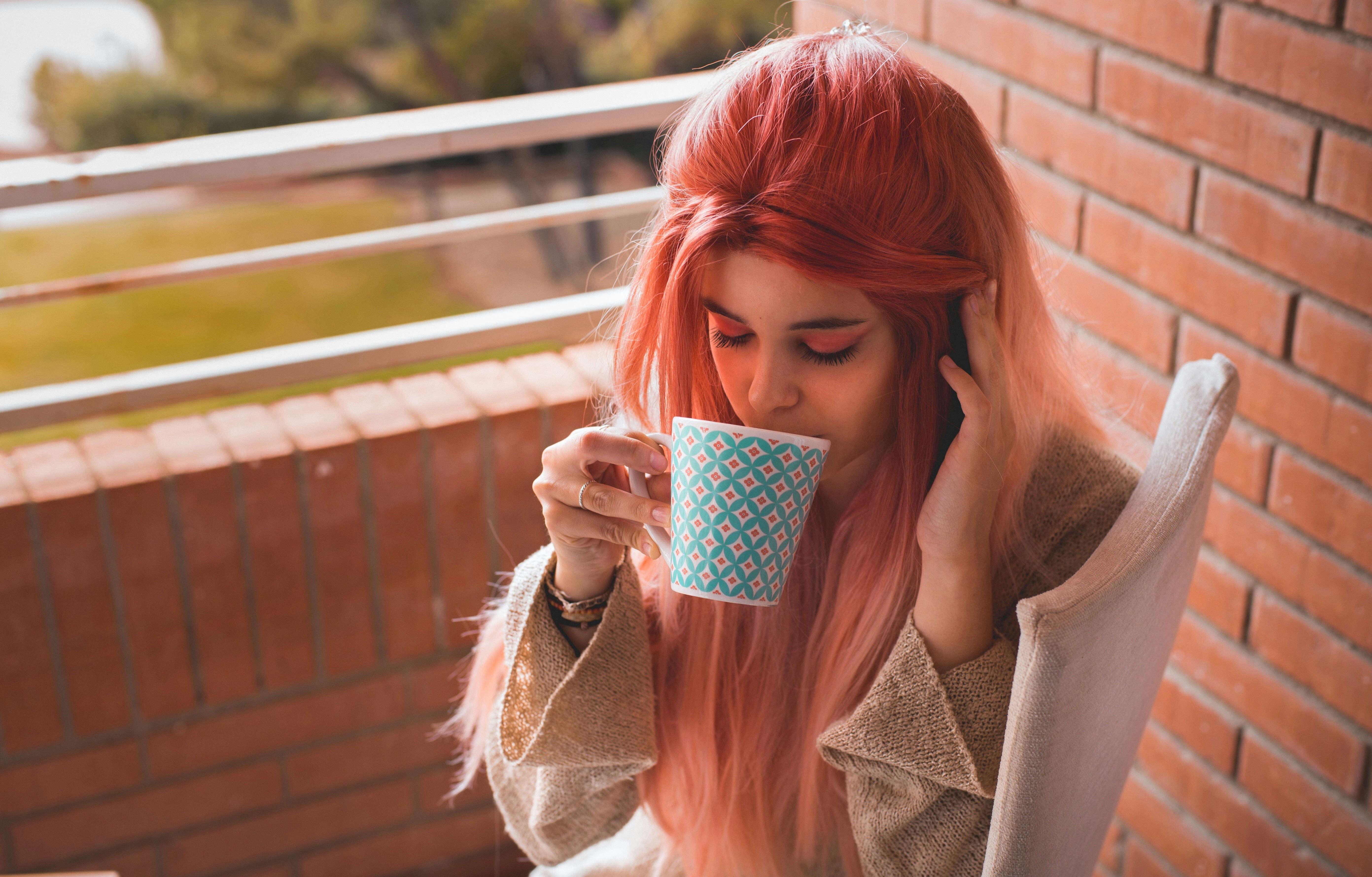 a woman sipping coffee wearing a hand tied wig