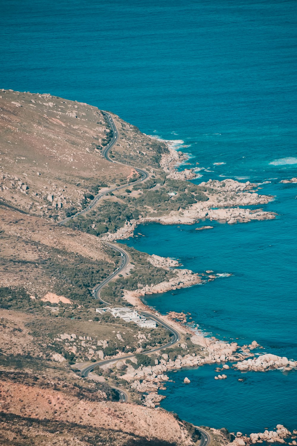 aerial photography of zig zag road beside body of water