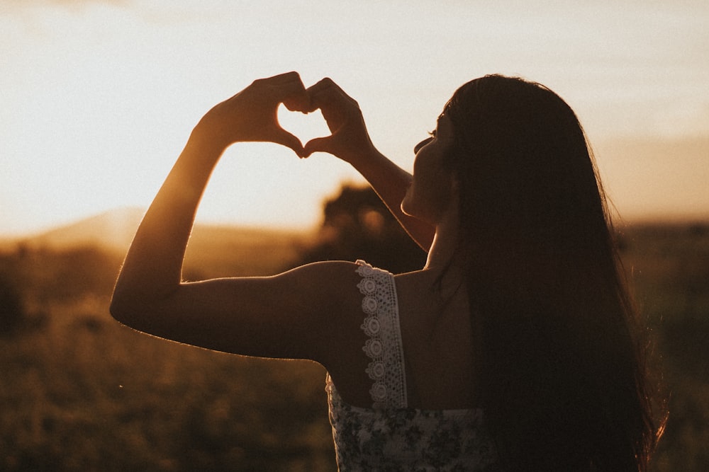 woman forming heart with her both hands showing a sign of self-worth