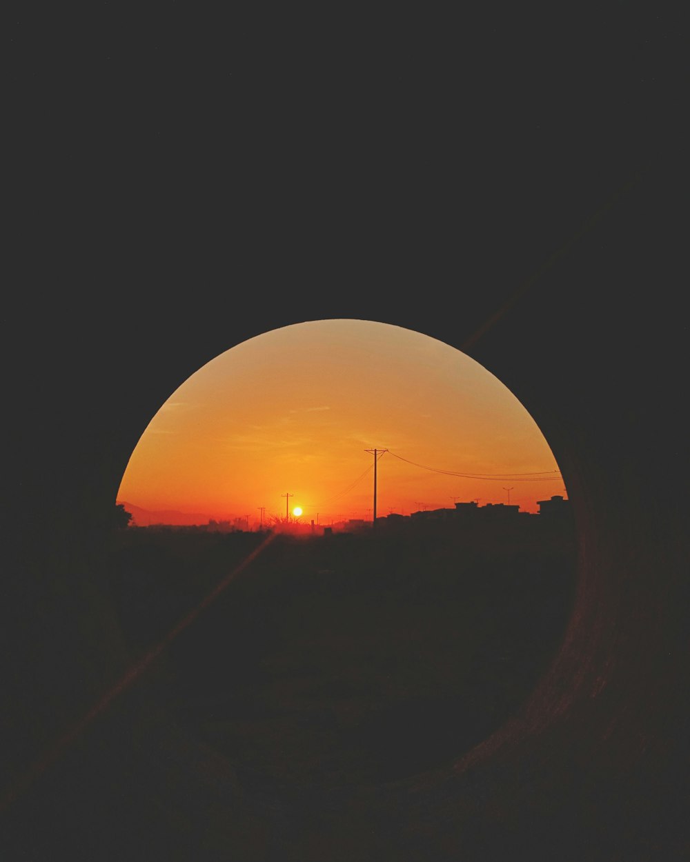 a sunset seen through a hole in a wall