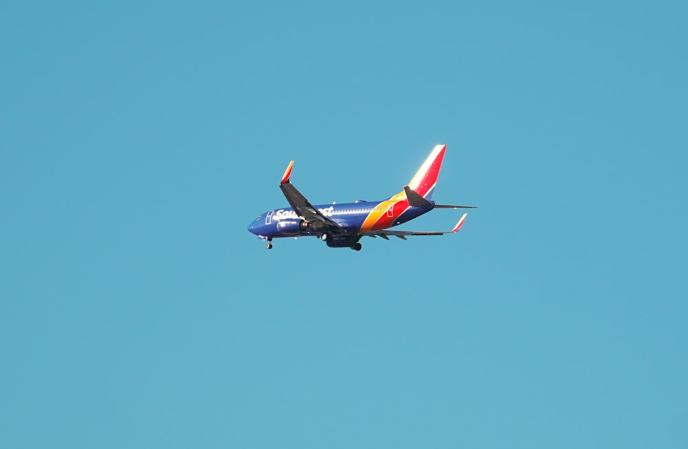 blue and red airplane flying in the sky