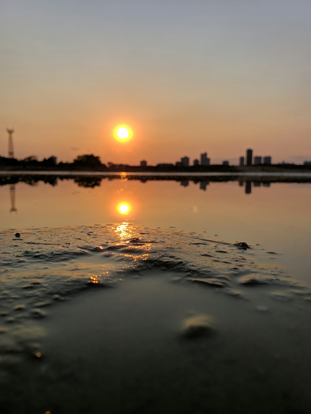 sunrise at the city through body of water